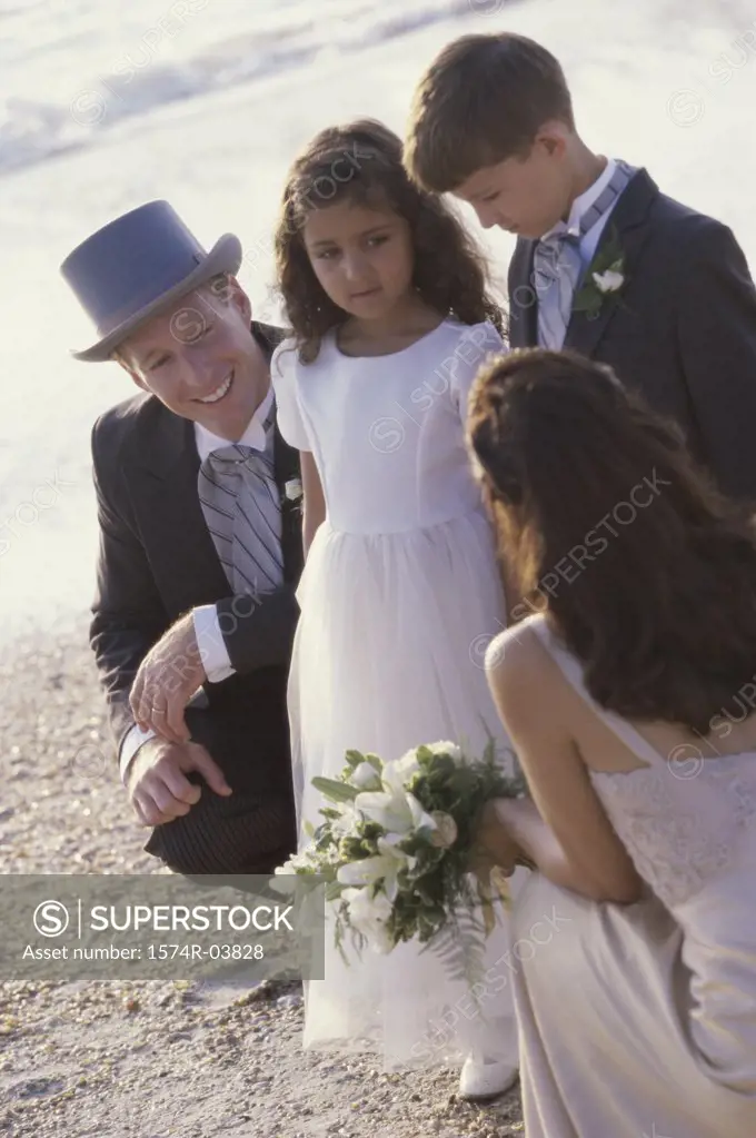 Newlywed couple on the beach with a flower girl and a ring bearer