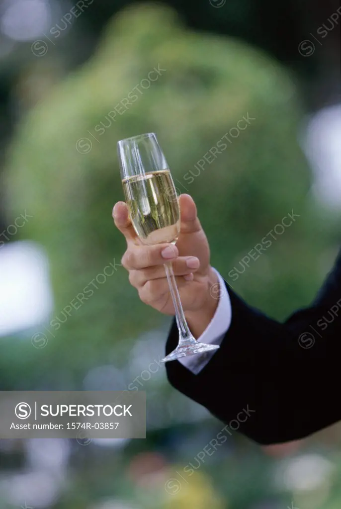 Close-up of a person's hand holding a champagne flute
