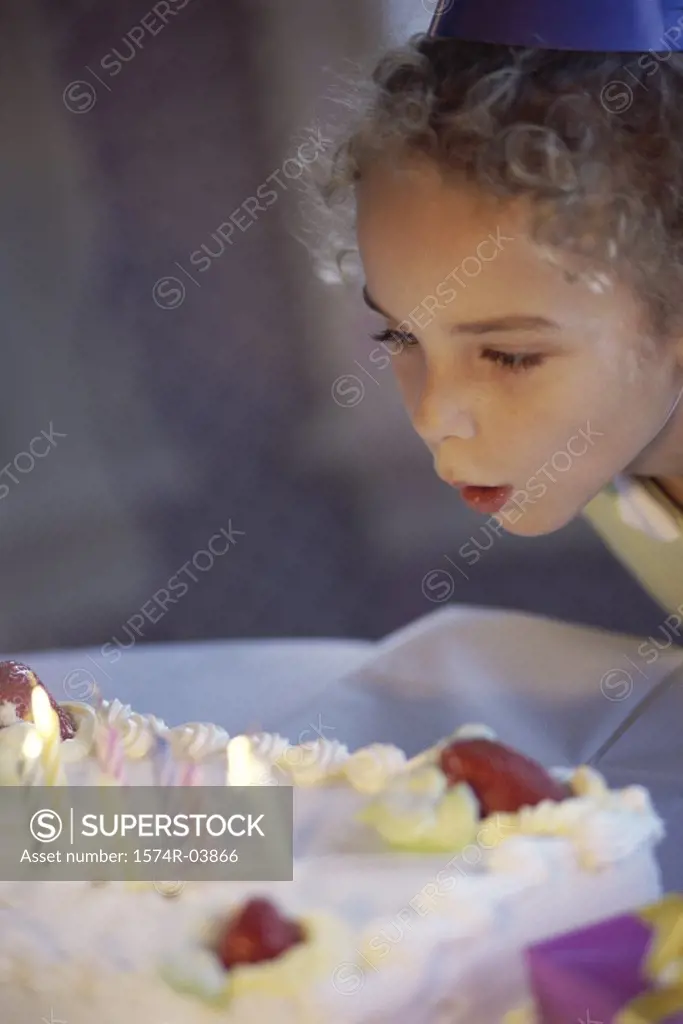 Girl blowing candles on her birthday cake