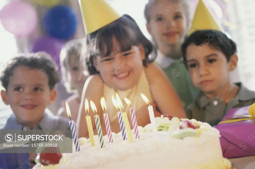 Group of children in front of a birthday cake at a birthday party