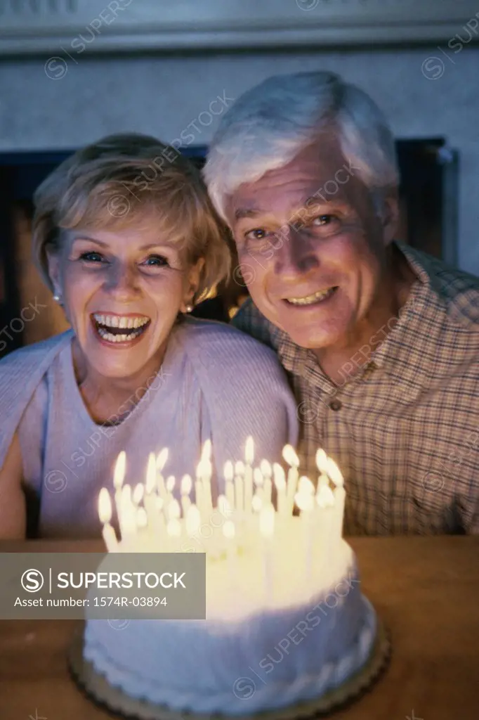 Senior couple blowing out candles on a cake