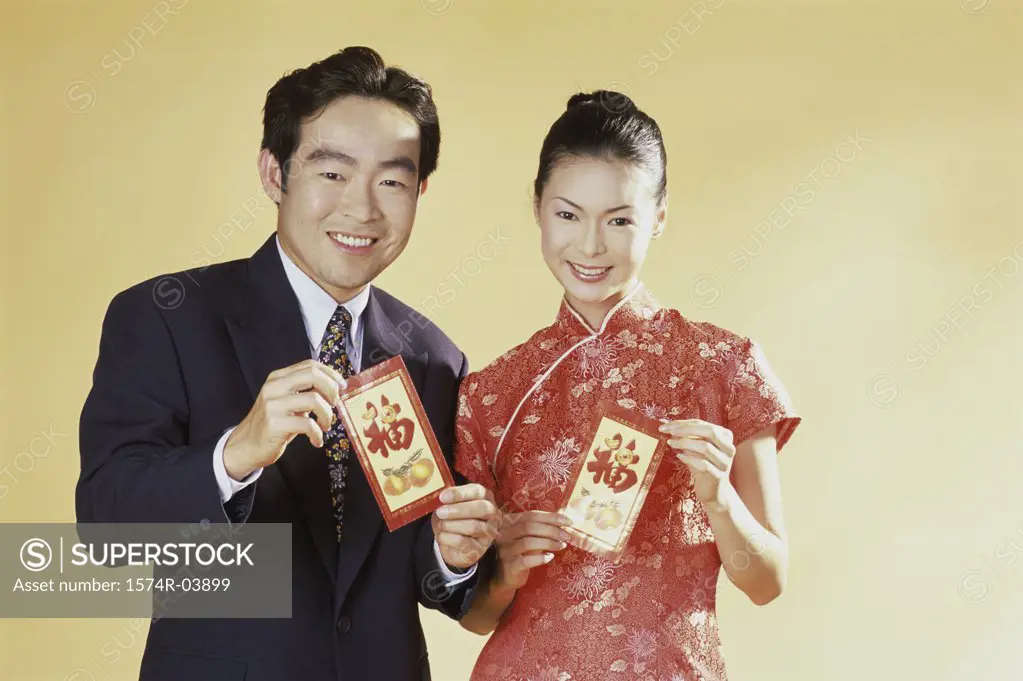 Portrait of a young couple holding greeting cards