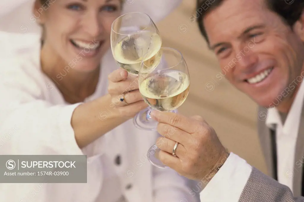 Mid adult couple toasting with glasses of wine