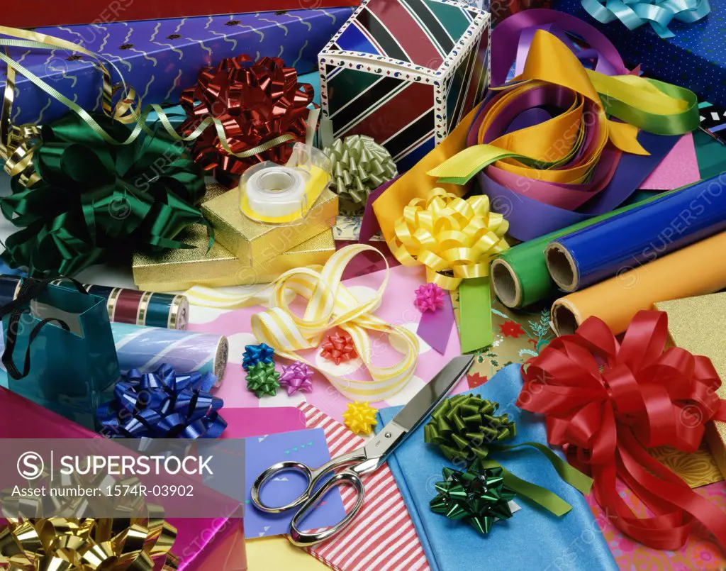 High angle view of ribbons with wrapping paper and a pair of scissors
