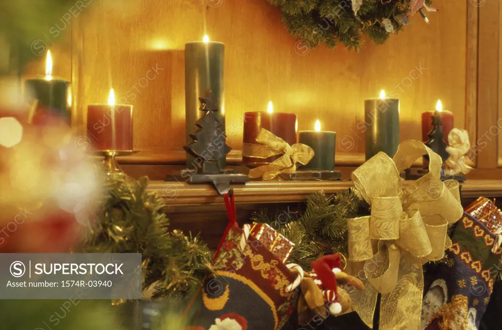 Lit candles and Christmas decorations on a mantelpiece