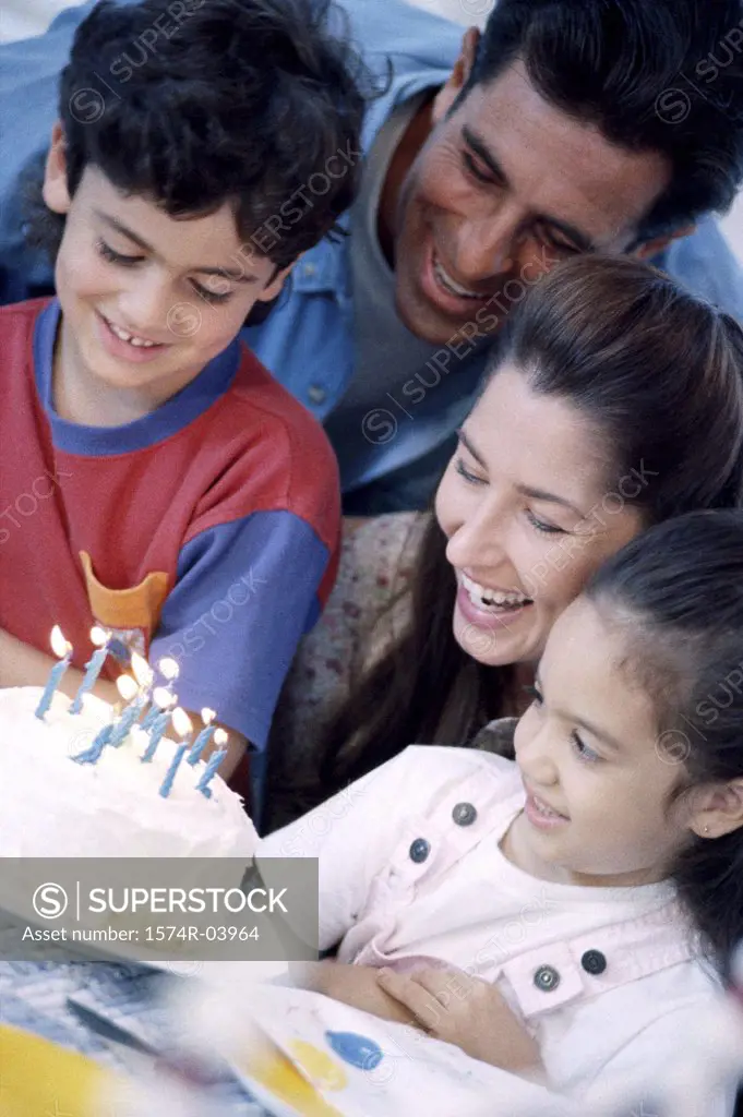 Parents with their son and daughter in front of a birthday cake