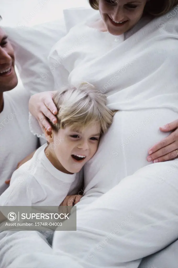 Son with his head against his pregnant mother's abdomen