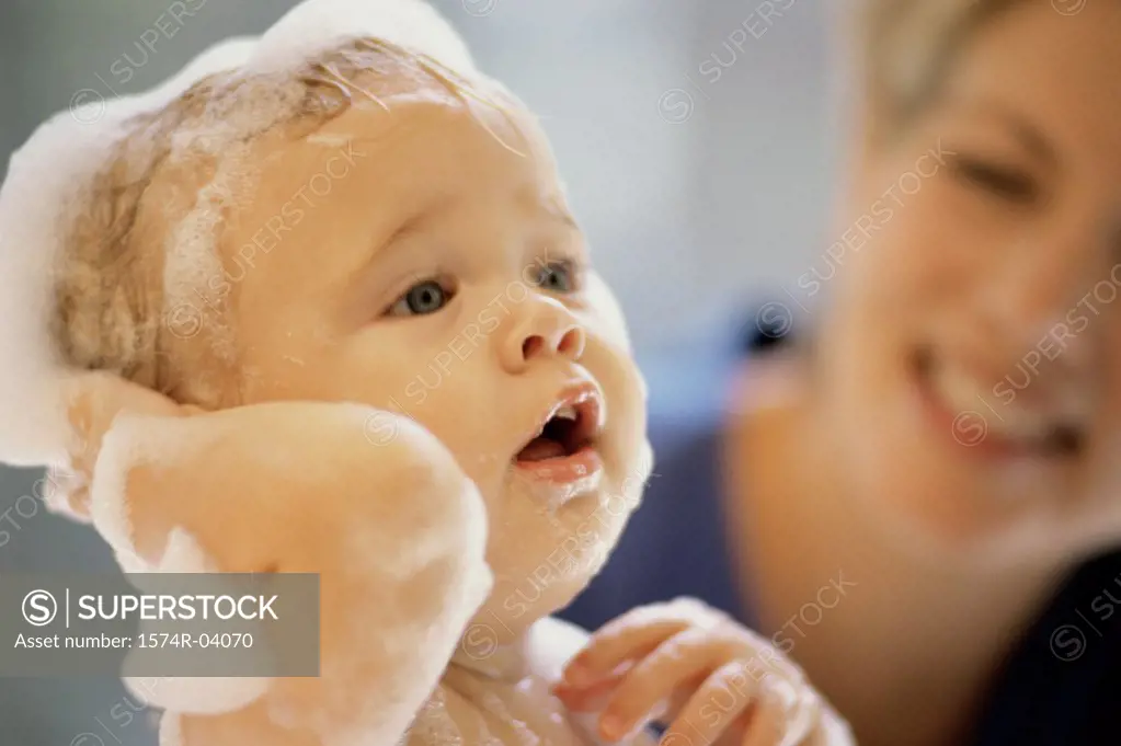 Close-up of a baby boy getting a bath from his mother