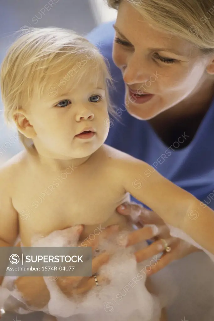 Baby boy getting a bath from his mother