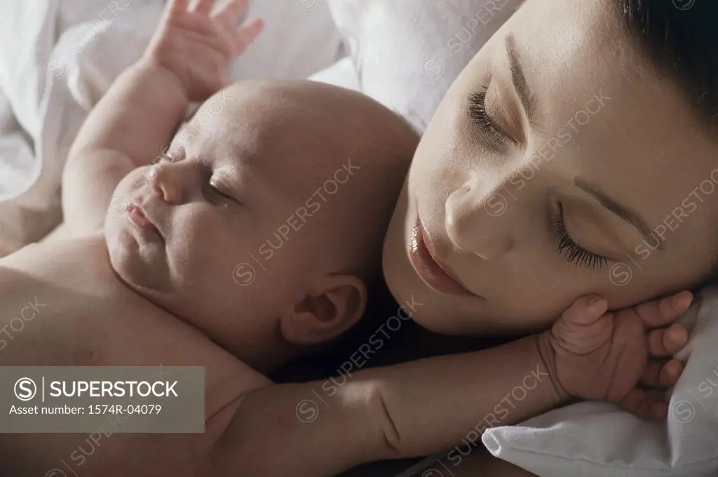 Close-up of a mother and her baby boy sleeping
