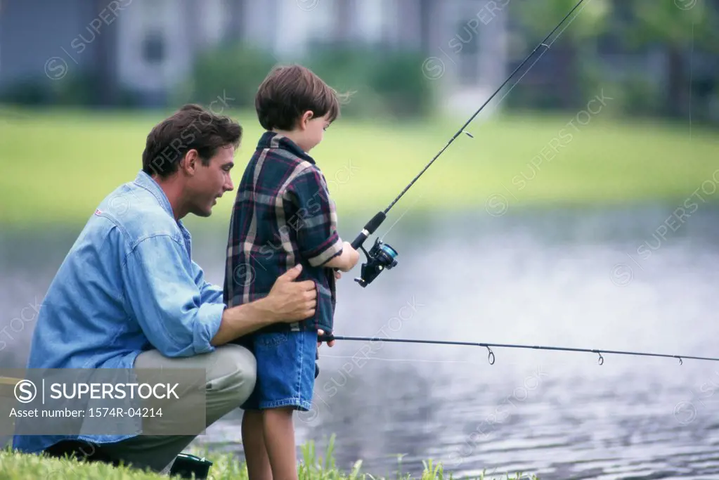 Side profile of a father and his son fishing