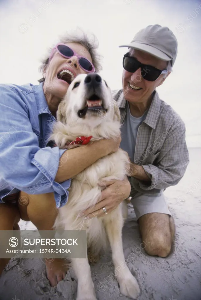 Senior couple hugging their dog