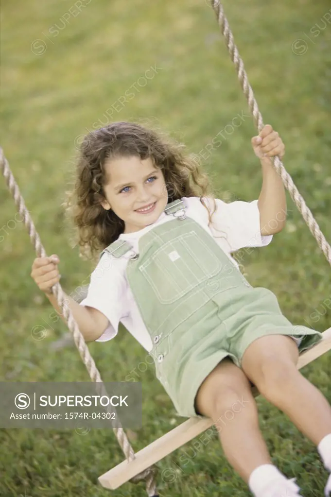 Front view of a girl sitting on a swing