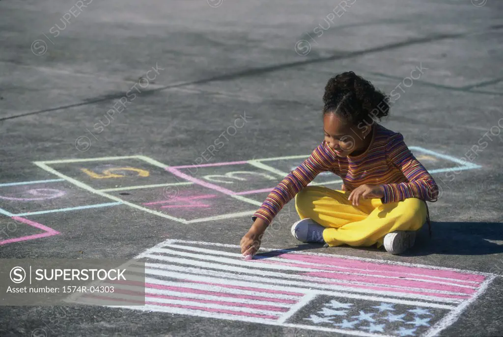 Girl drawing the American flag on the ground with chalk