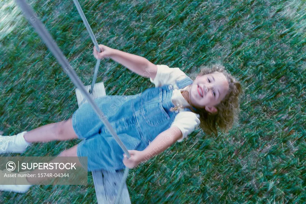 High angle view of a girl sitting on a swing