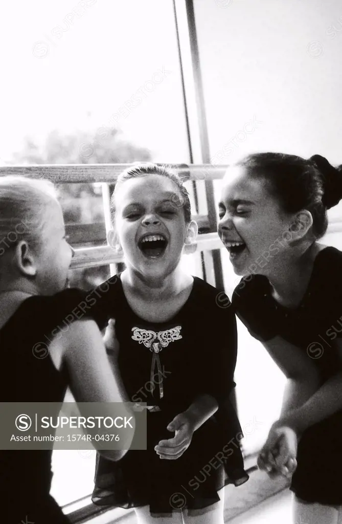 Three ballerinas laughing