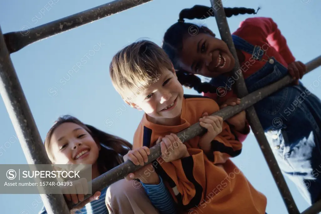Portrait of a boy and two girls on monkey bars