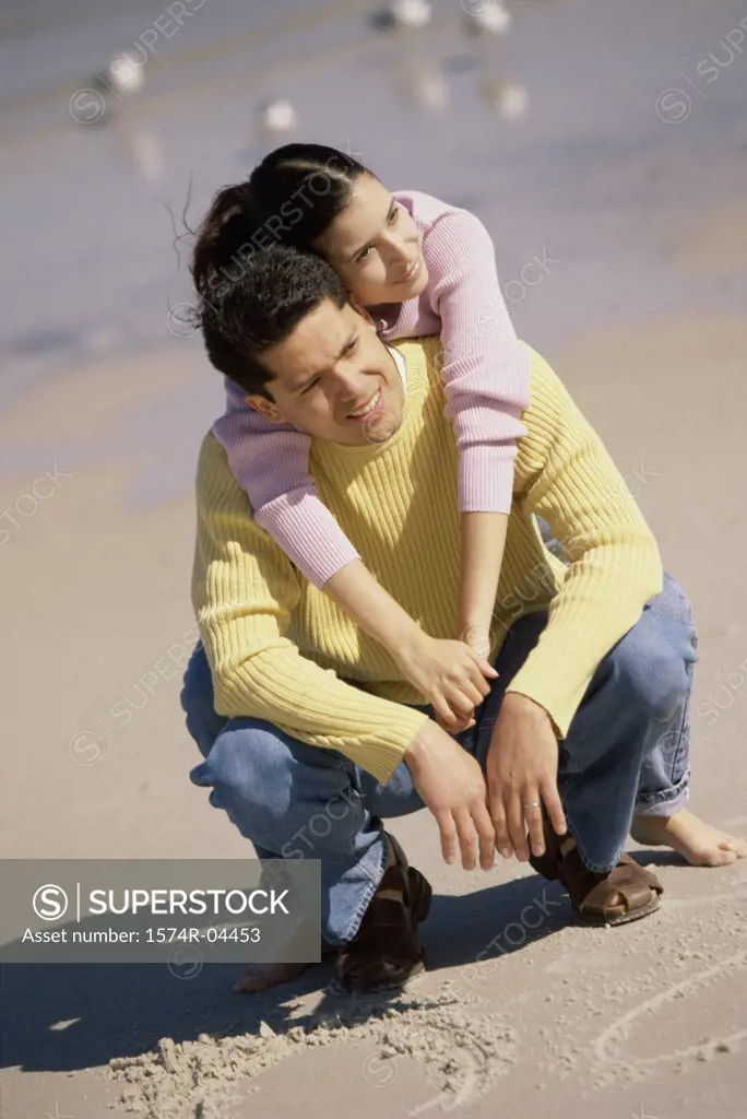 Young woman leaning against a young man on the beach
