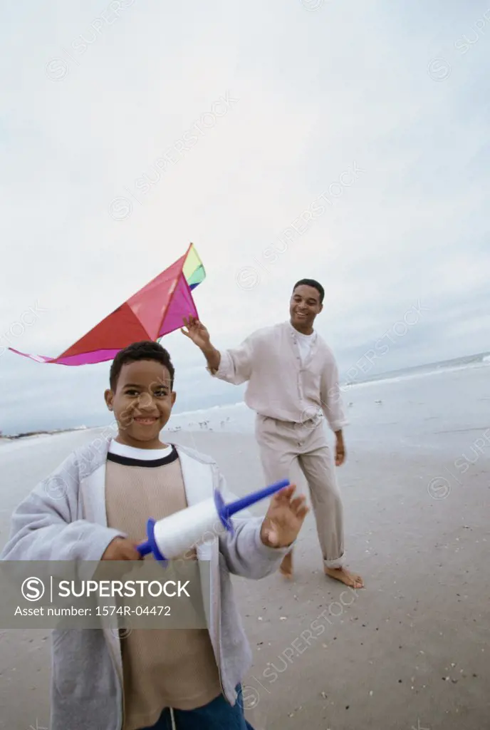 Father and his son flying a kite on the beach