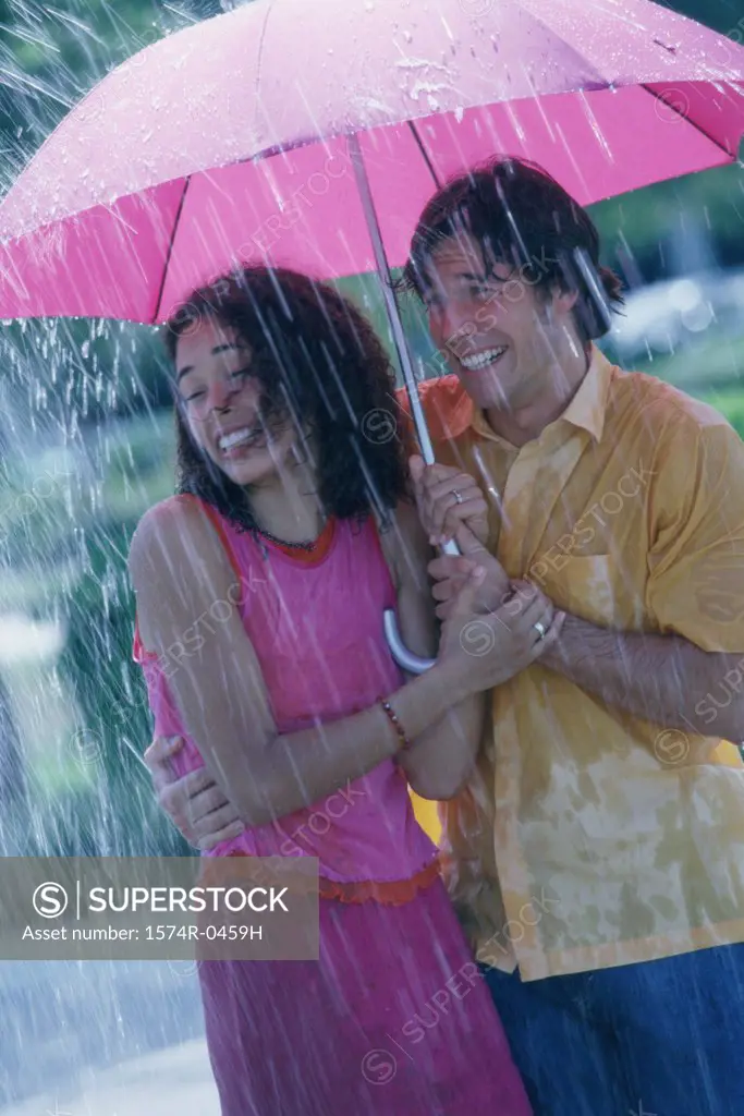 Young couple standing under an umbrella