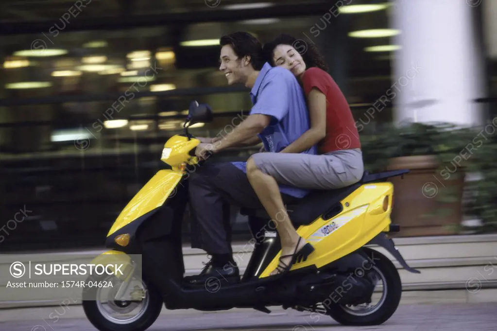 Young couple riding on a motor scooter