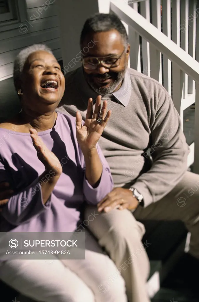 Senior couple sitting on stairs laughing