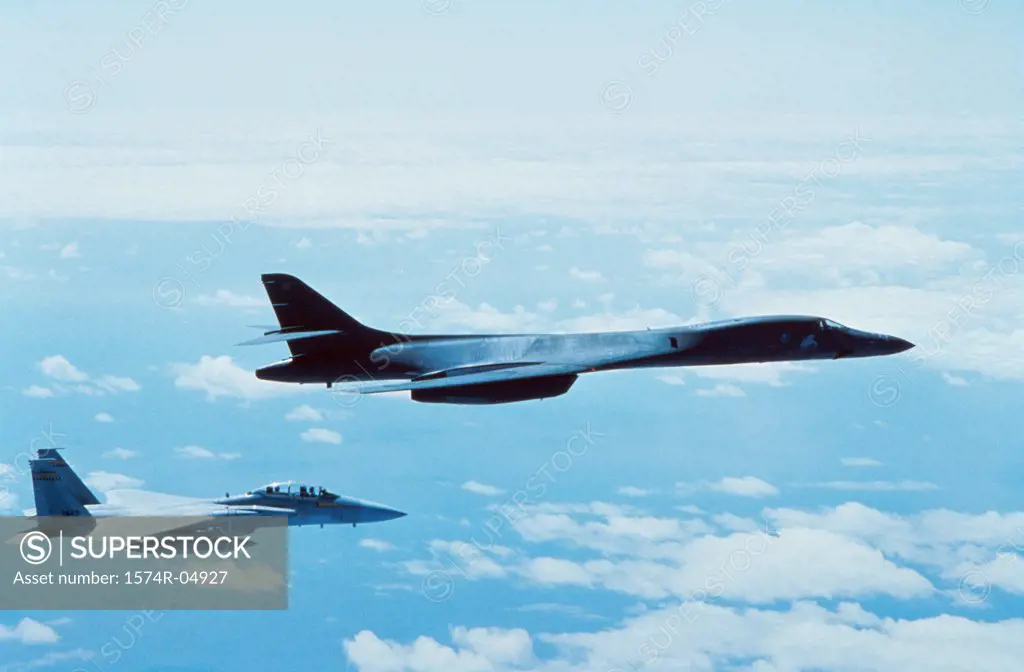 Side profile of a B-1B Lancer with another aircraft in flight