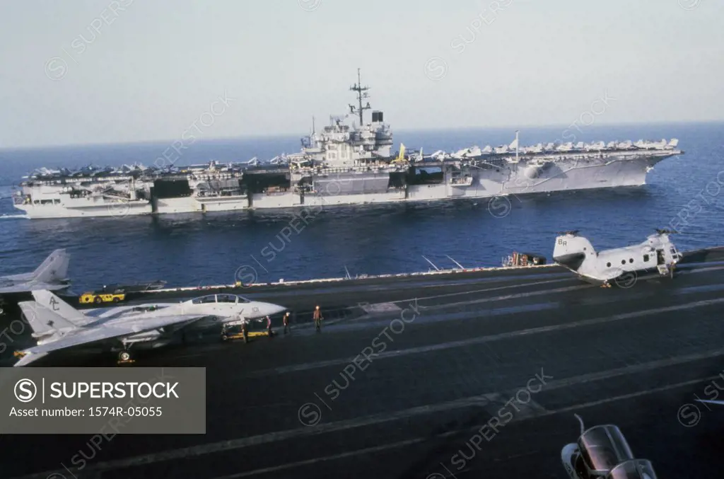USS Saratoga and the USS John F. Kennedy sailing alongside in the sea