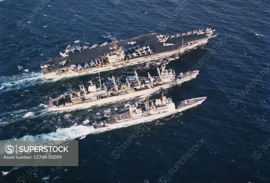 Aerial view of three military ships sailing in the sea