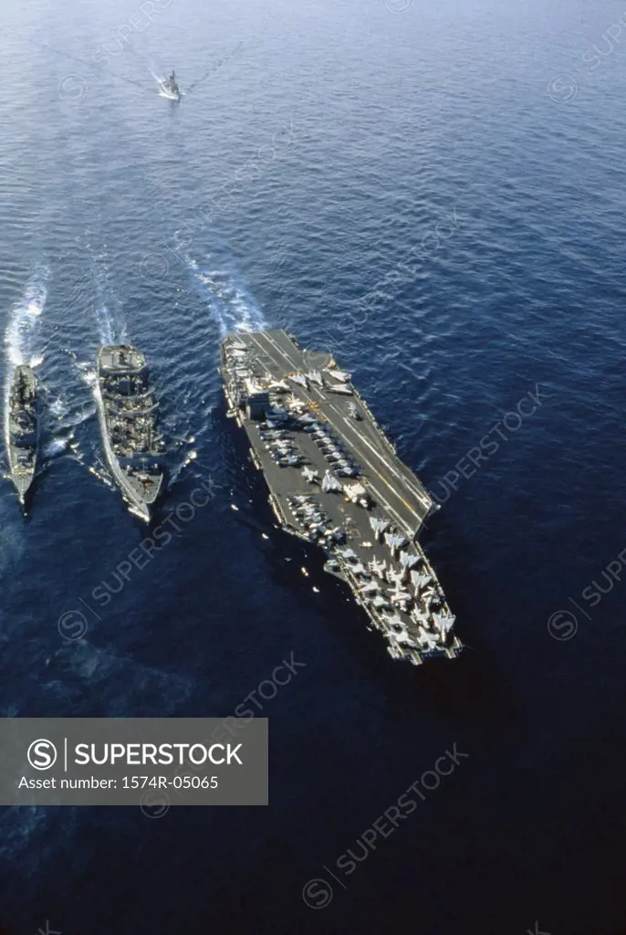 Aerial view of the USS Nimitz aircraft carrier with three warships in the sea