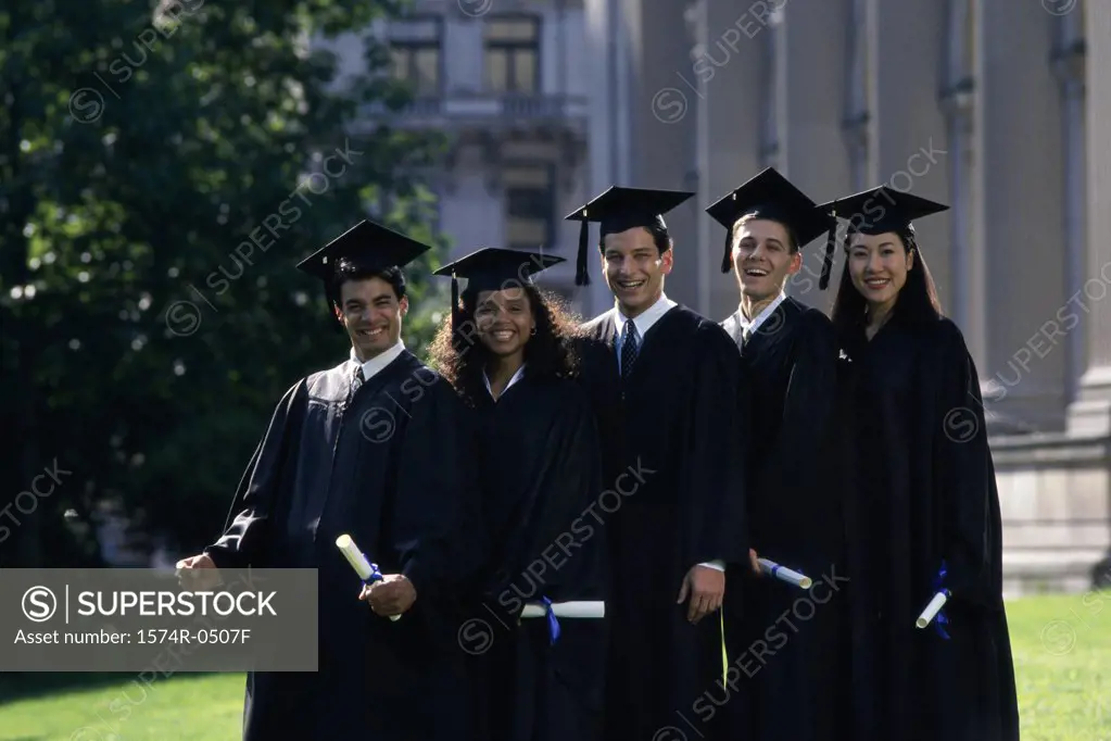 Two female graduates and three male graduates holding diplomas