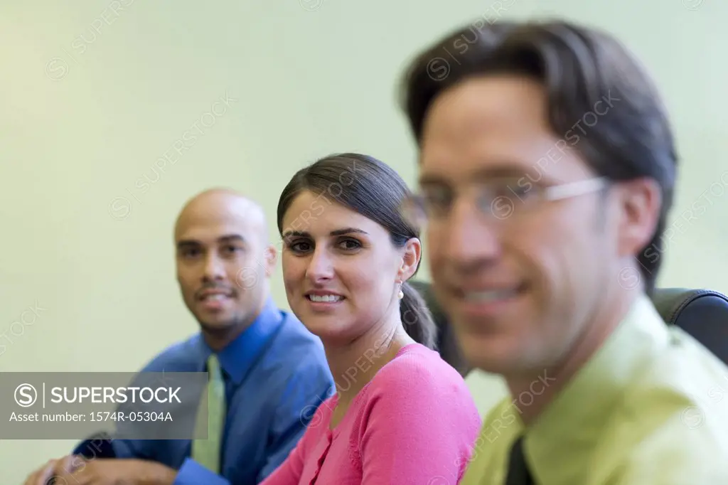 Two businessmen and a businesswoman sitting in a conference room