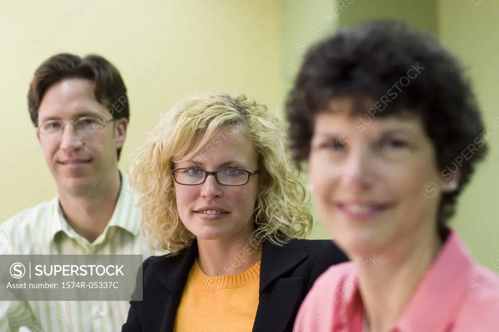 Portrait of two businesswomen and a businessman sitting in a conference room
