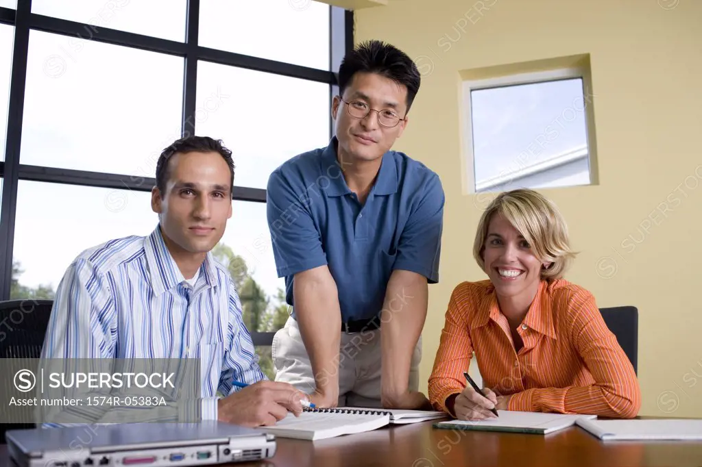 Portrait of two businessmen and a businesswoman in a conference room