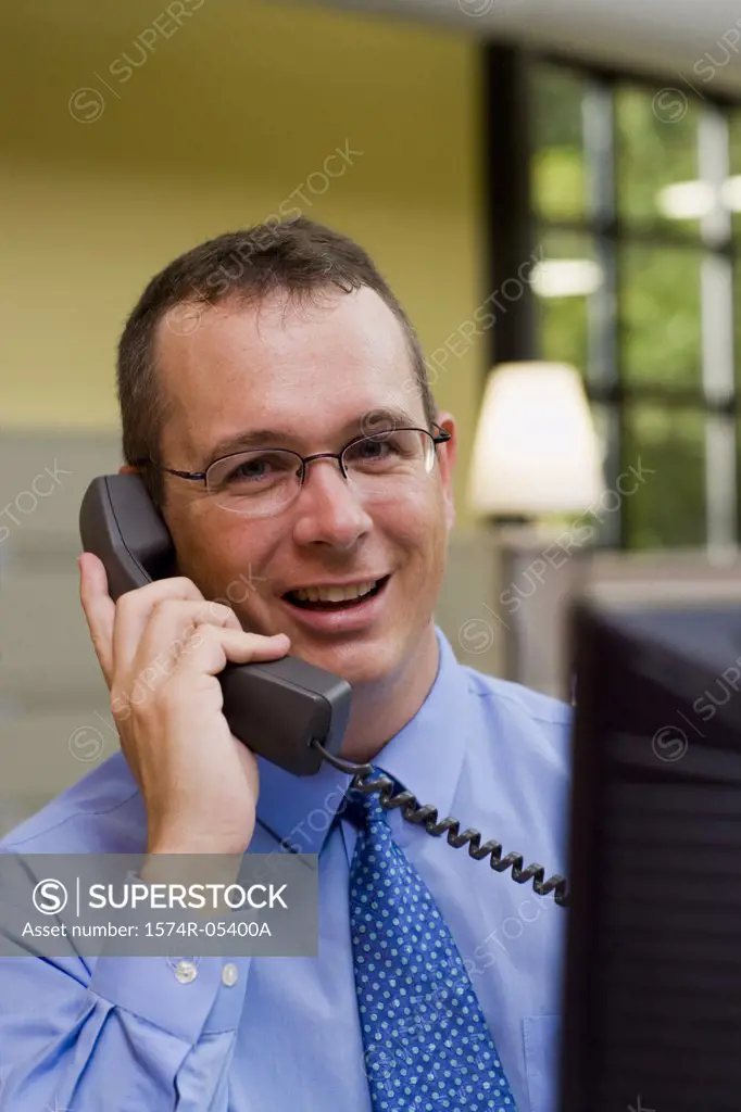 Portrait of a businessman sitting in an office talking on a telephone
