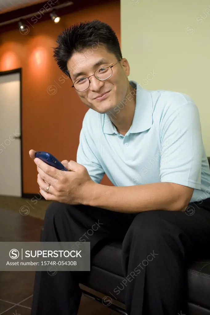 Portrait of a businessman sitting in an office holding a mobile phone