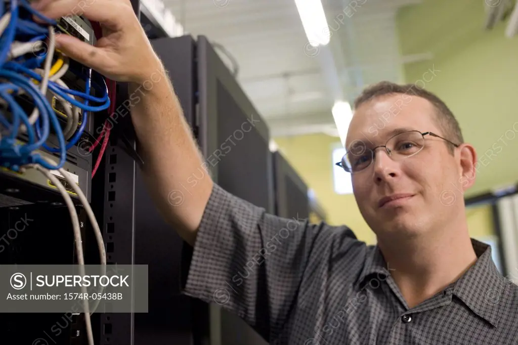 Technician inspecting cables of a network server