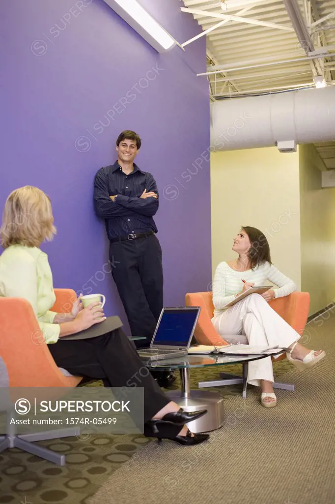 Two businesswomen and a businessman talking to each other