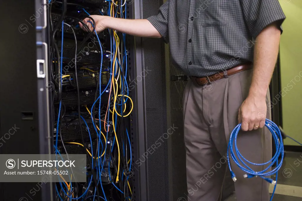 Mid section view of a technician attaching cables to a network server