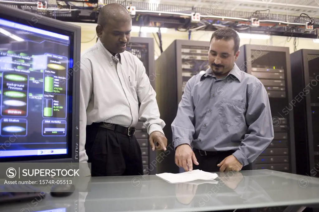 Two technicians standing in front of a network server