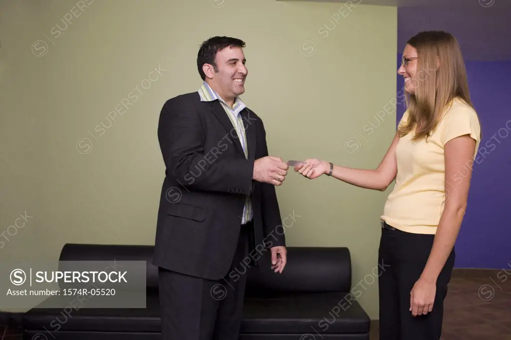 Businesswoman giving a business card to a businessman