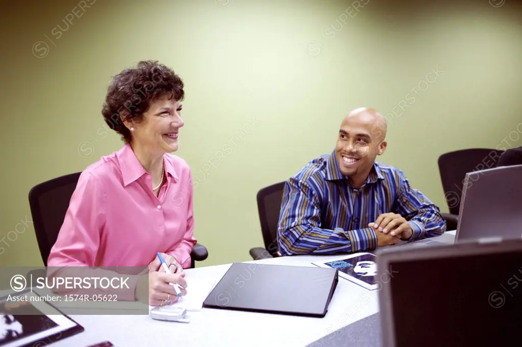 Businessman and a businesswoman sitting in a conference