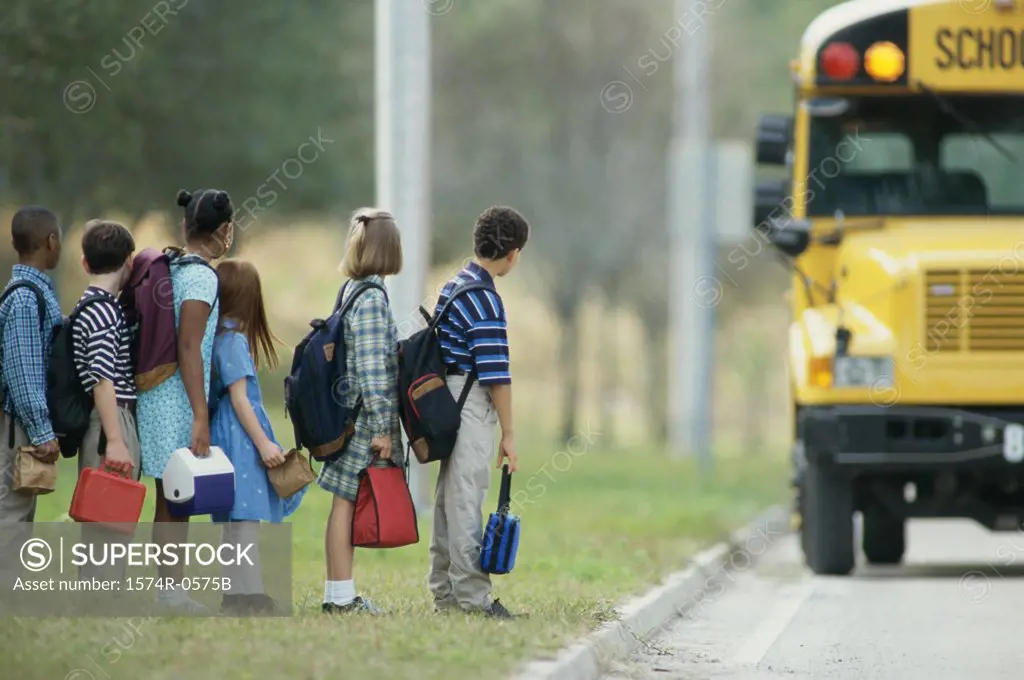 Side profile of students standing in line for a school bus
