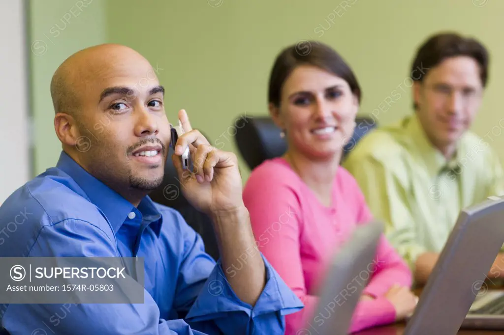 Portrait of two businessmen and a businesswoman sitting in a conference room