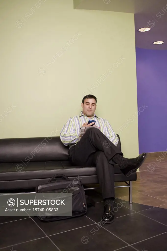 Businessman sitting in an office working on a palmtop