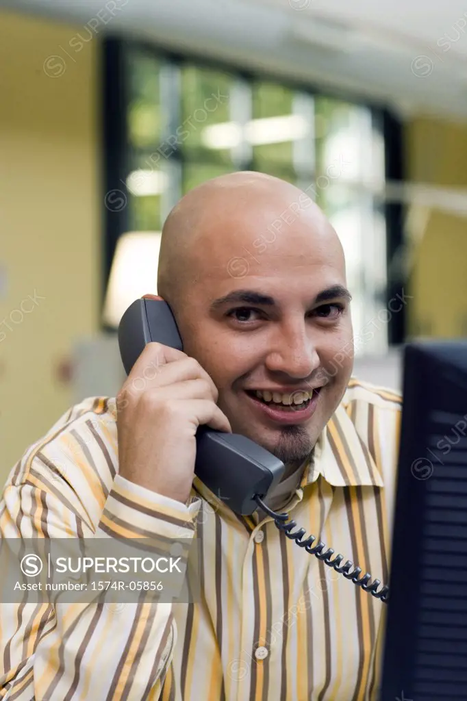 Portrait of a businessman sitting in an office talking on a telephone