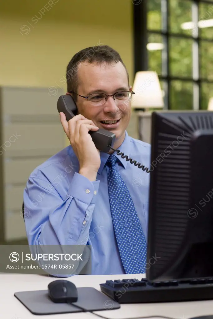 Businessman sitting in an office talking on a telephone