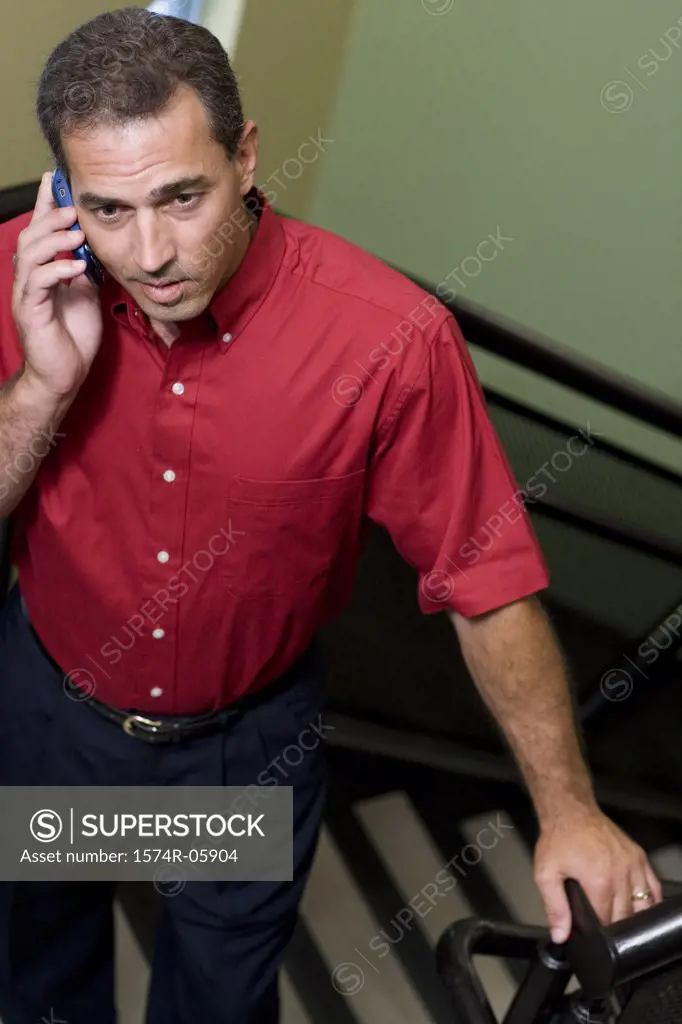 High angle view of a businessman standing on stairs talking on a mobile phone
