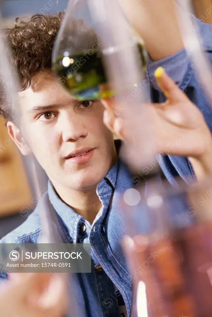 Teenage boy holding a flask in a chemistry laboratory