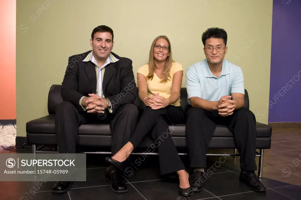 Portrait of two businessmen and a businesswoman sitting on a couch